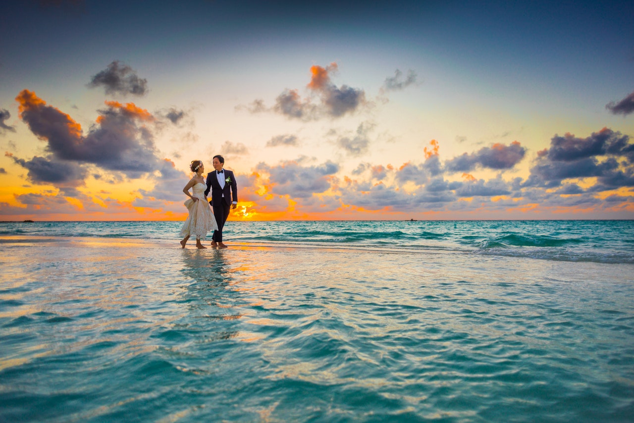 Married couple walking on beach