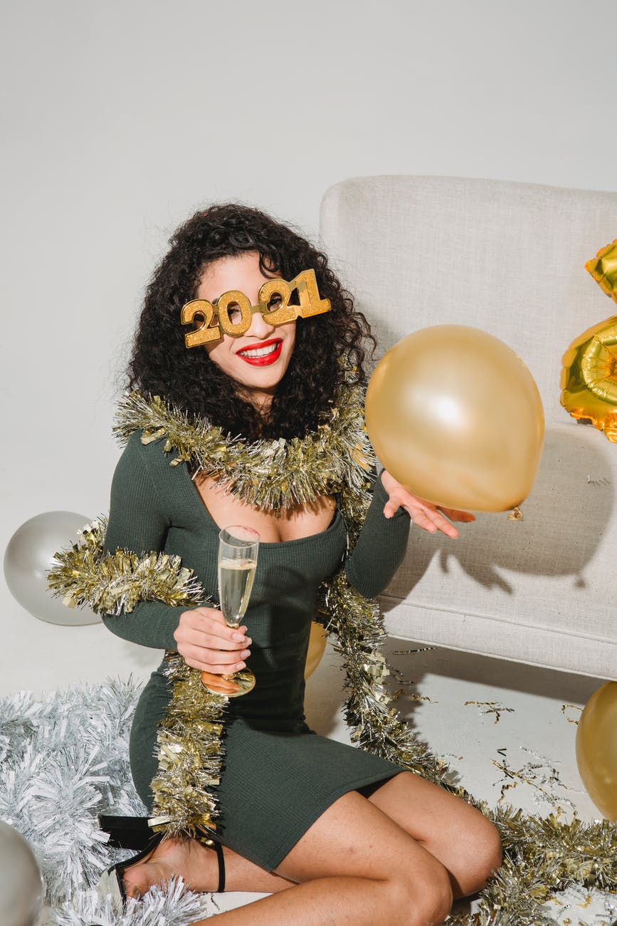 happy woman in festive glasses and tinsel smiling